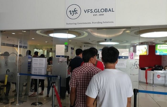 Mọi người đứng xếp hàng để làm thủ tục xin visa Anh 